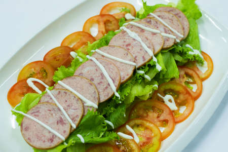 Sliced ham on tomato and saladの写真素材