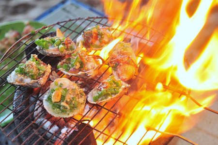 Grilling shellfish and seafood on hot fireの写真素材
