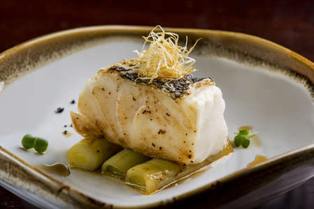 Fried toothfish with onion on dish