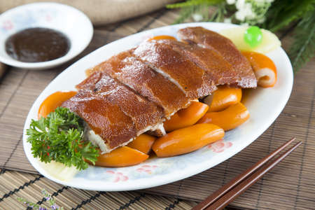 Roasted pork skin with fried pig's gut and herbs on white plate on the table in restaurantの写真素材