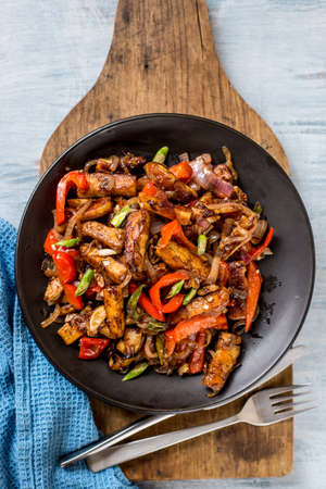 Crispy tofu in chinese style with garlic sauce on wooden cutting board