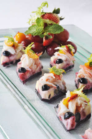 Shrimp cake with strawberry and grape on the tableの写真素材