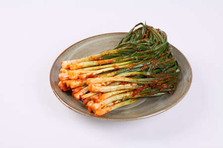 Korean green onion kimchi on plate on white backgroundの写真素材