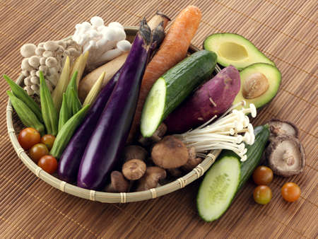 Basket of vegetables and produce on bamboo tableの写真素材