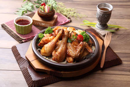Fried chicken on black plate with lemon and herbs