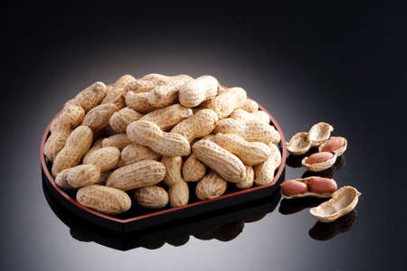 Dried salted peanuts on black plate in restaurant