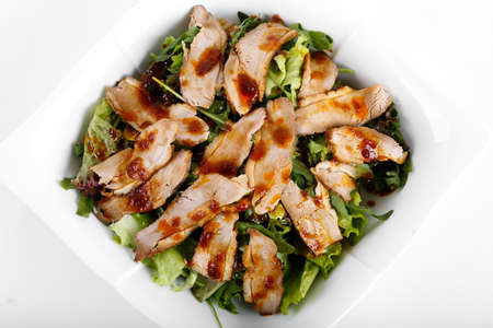 Sliced roasted fried pork with salad on white plateの写真素材