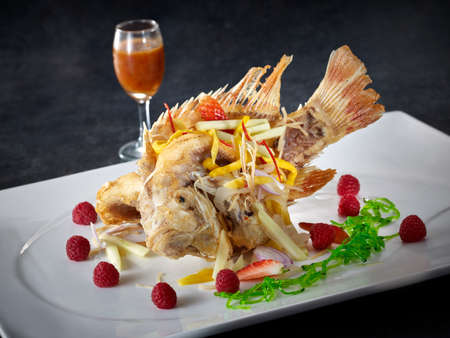 Hong Kong Style fried Tilapia fish on white plate