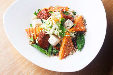 Salad with pumpkin and chickpeas on white plateの写真素材