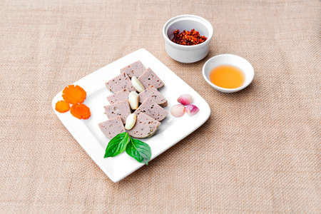 Vietnamese cinnamon rolls or pork sausag on white plate with herbs, onion and chili sauceの写真素材