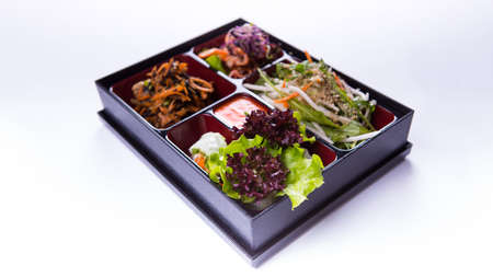Bento box salad of lettuce, cabbage and kimchi on white backgroundの写真素材