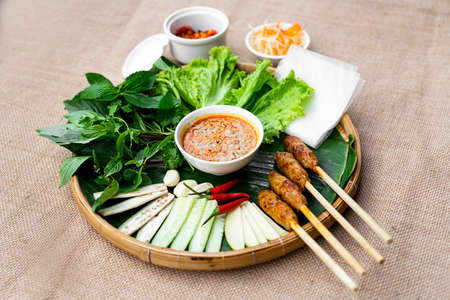 Vietnamese fermented pork roll or nem Hue with lettuce, herbs and chili sauce on bamboo tray
Vietnamese fermented pork rollの写真素材