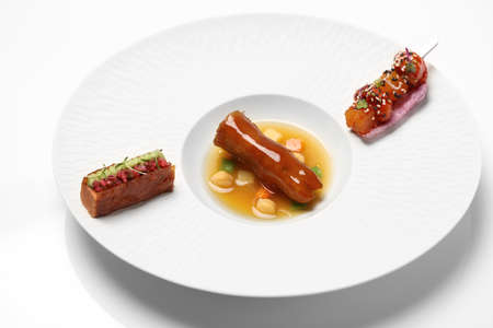Sauteed pork foot with sauces on white plate in restaurantの写真素材