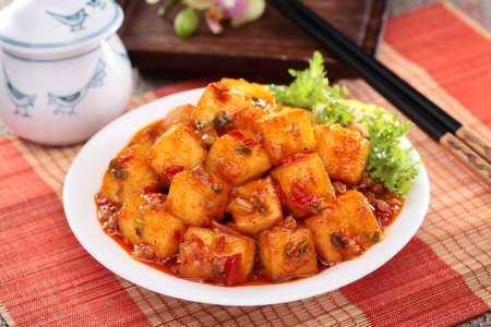 Mapo tofu with lettuce and tea pot on white plate on bamboo trayの写真素材