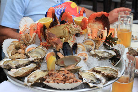 Seafood buffet with fresh oysters, clams, crabs, shrimps, snails, lobsters and beer in restaurantの写真素材