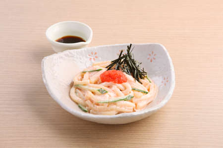 Japanese noodle of Hakata Mentai Mayo Udon with soyal sauce on wooden tableの写真素材