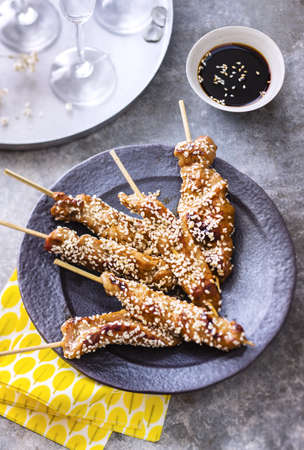 Mini skewers of veal yakitori on black plate with soyal sauceの写真素材