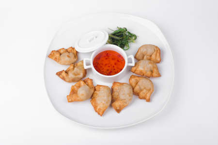 Fried dumplings with chili fish sauce on white plate backgroundの写真素材
