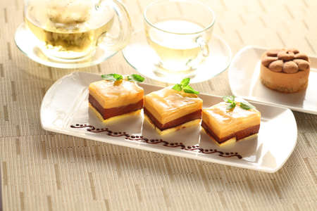 Pudding cake with mint leaves on white plate with tea