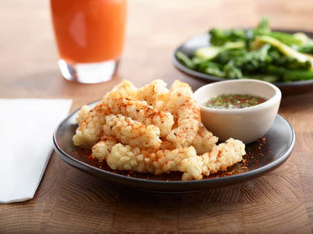 Lifestyle Chilli fried Squid with sauce and carrot juice on wooden tableの写真素材