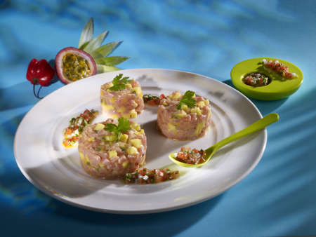 Pineapple passion veal tartare on white plate in restaurantの写真素材