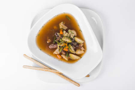 Soup of Aries with broccoli, mushroom, green beans and cabbage in white plate backgroundの写真素材