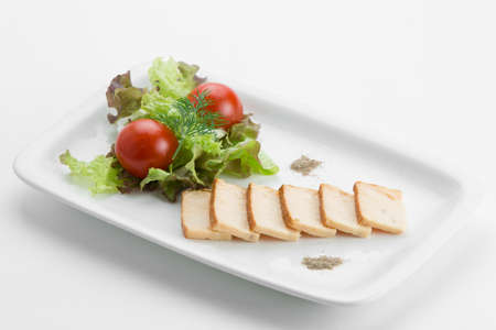 Oily fish smoked with mixed salad lettuce and tomatoes on white plateの写真素材