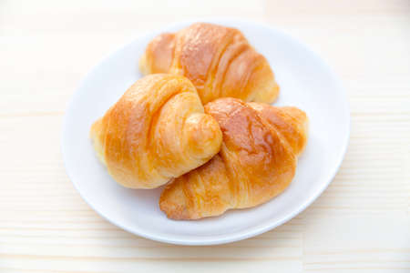 Croissant bread on white plate in restaurantの写真素材