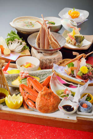 Meal of red crab with tempura, lemon, mushroom, wasabi and sauce on wooden trayの写真素材