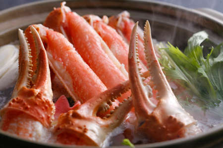 Hot pot of crab claws and legs in big stew with herbs in asian restaurantの写真素材