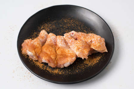Fresh raw chicken meat seasoned with spices and chili on black dishの写真素材
