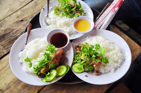 Vietnamese broken rice or com tam with fried chicken legs, pork and herbsの写真素材