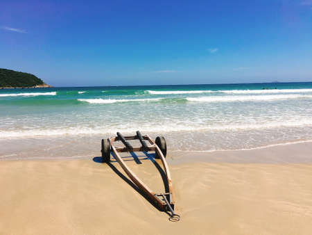 The wheelbarrow on the beach with sea wave foamの写真素材