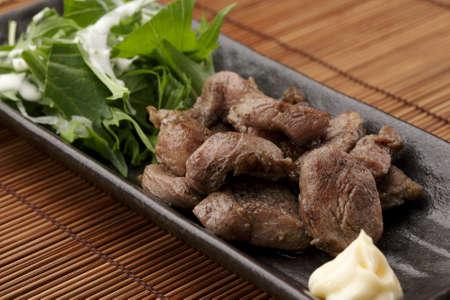Black platter of sauteed beef with herbsの写真素材