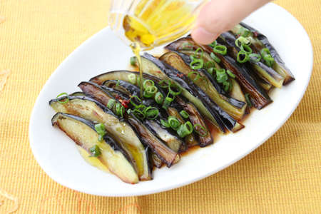 Grilled eggplants with oil and onion on white platterの写真素材