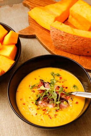 Pumpkin and lentil soup with crispy baconの写真素材