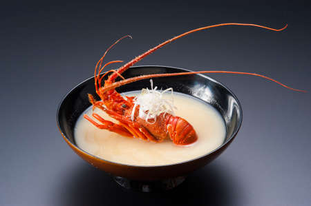 Lobster soup with whole red shrimp in black bowlの写真素材