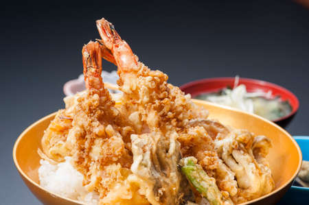 Fried tempura of shrimp and vegetables in bowl in black backgroundの写真素材