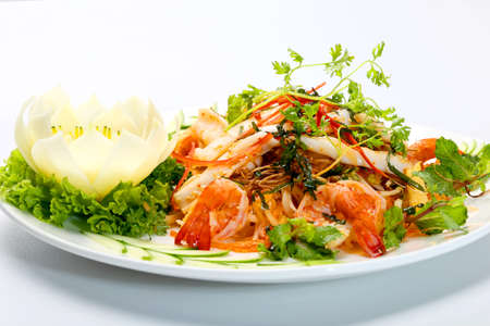 Seafood salad with shrimp, squids lettuce, mint leaves and herbs on white dishの写真素材