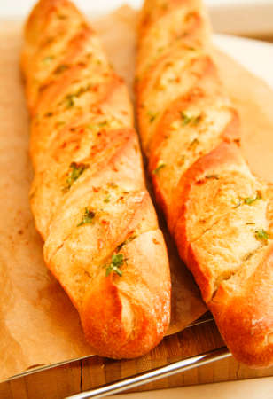 French style bread with wrapped paper on wooden boardの写真素材