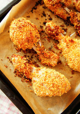 Fried chicken legs in black pan with wrapped paperの写真素材