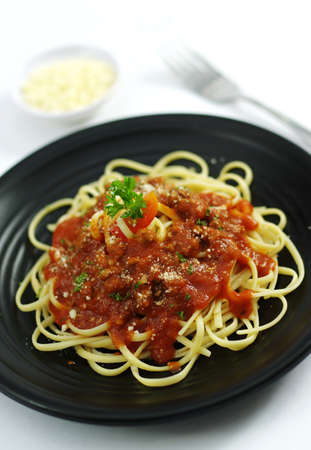 Spaghetti ramen noodle pasta  with tomatoes sauce on black dishの写真素材
