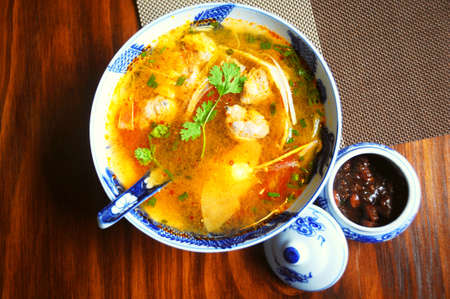 Bowl of Vietnamese sour soup with bamboo shoots and fish ballsの写真素材