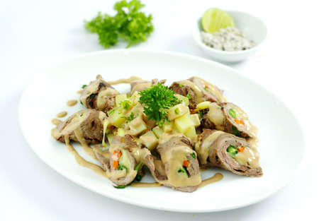 Beef rolls with cheese and lime salt on white platterの写真素材