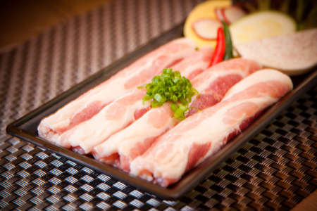 Fresh sliced pork with onion and lime on trayの写真素材