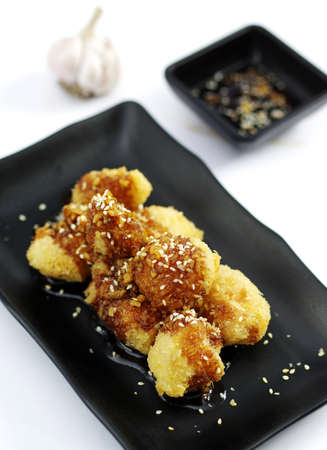 Sauteed chicken balls with Japanese sauce on black platterの写真素材