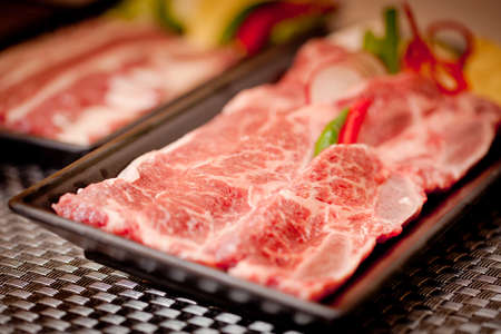 Fresh raw sliced beef with chili on black trayの写真素材