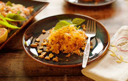 Carrot salad with peanuts and lemon on dishの写真素材
