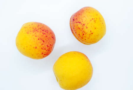 Delicious juicy apricots are located on a white background