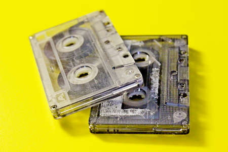 Old audio cassettes laid out on a yellow background